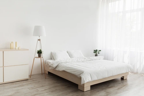 ห้องนอนสไตล์มินิมอลปูพื้นลายไม้ตัดกับผนังสีขาว